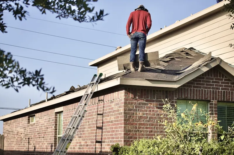 Professional roofer working on a residential roof in Amber Sweet Farms